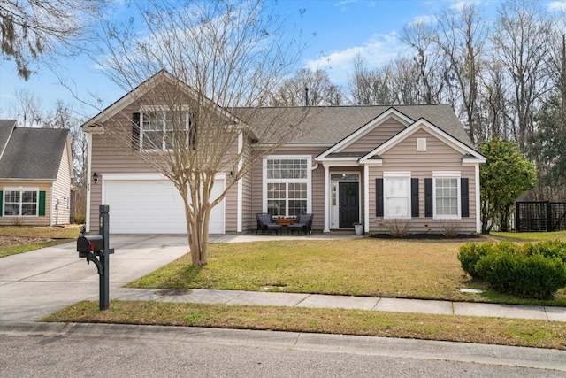 traditional-style house featuring concrete driveway, a garage, a front yard, and roof with shingles