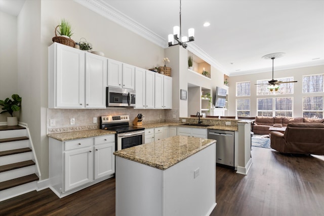 kitchen with a sink, stainless steel appliances, backsplash, and ornamental molding