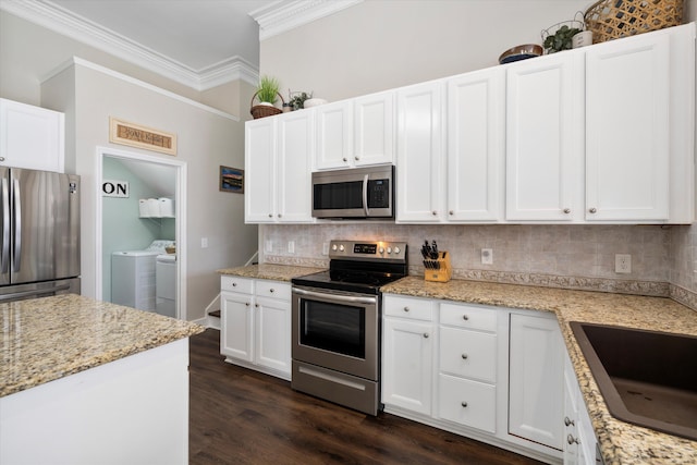 kitchen with ornamental molding, separate washer and dryer, backsplash, and stainless steel appliances