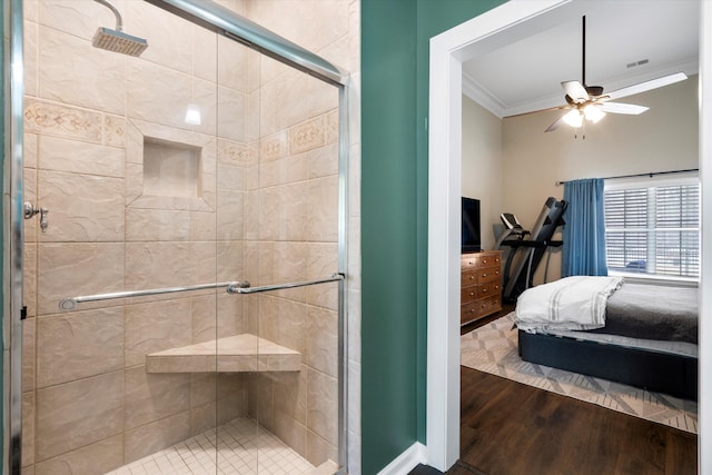 full bath featuring ceiling fan, ornamental molding, a stall shower, wood finished floors, and ensuite bath