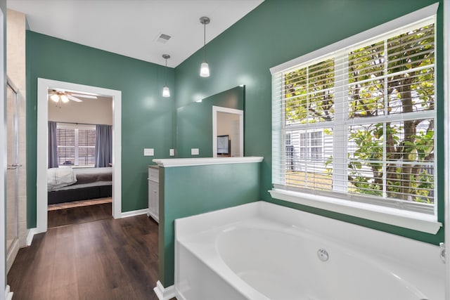 ensuite bathroom with visible vents, a garden tub, ensuite bathroom, wood finished floors, and vanity