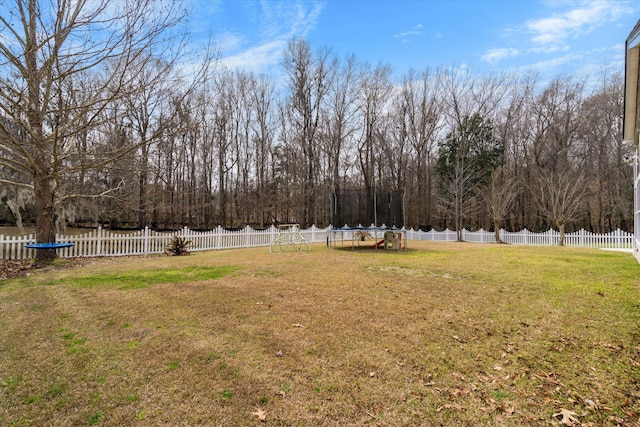 view of yard with a trampoline and a fenced backyard