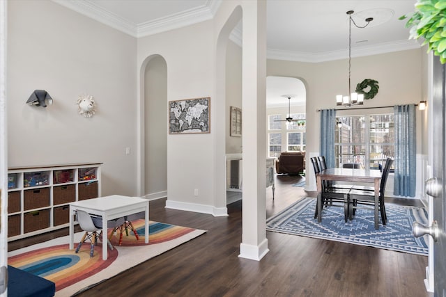 dining room with wood finished floors, arched walkways, and ornamental molding