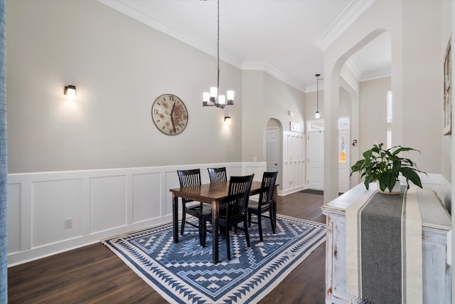 dining room featuring an inviting chandelier, dark wood-type flooring, arched walkways, and ornamental molding