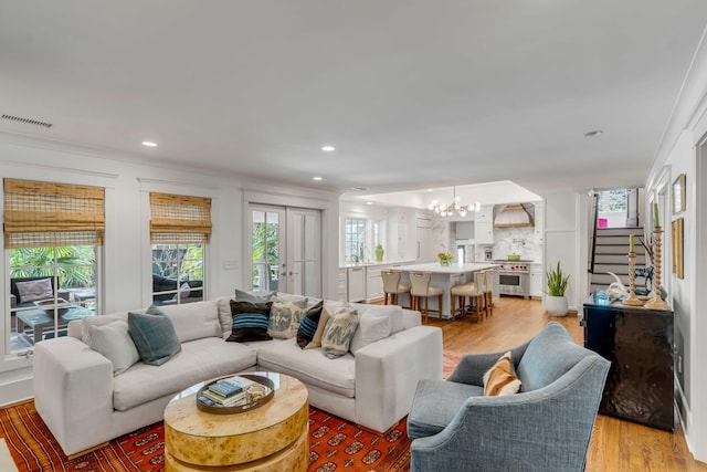 living room with recessed lighting, visible vents, light wood-style floors, and an inviting chandelier