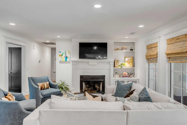 living room with recessed lighting, a fireplace, and crown molding