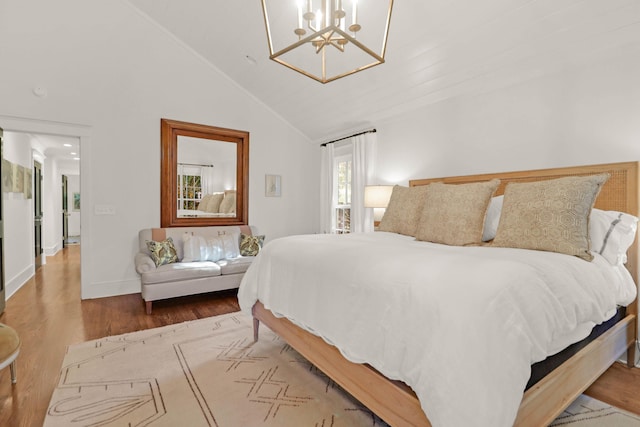 bedroom featuring baseboards, a notable chandelier, wood finished floors, and vaulted ceiling