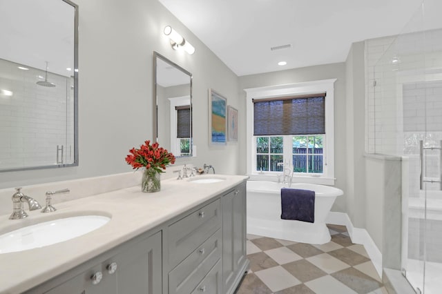 bathroom featuring double vanity, tile patterned floors, a stall shower, and a sink