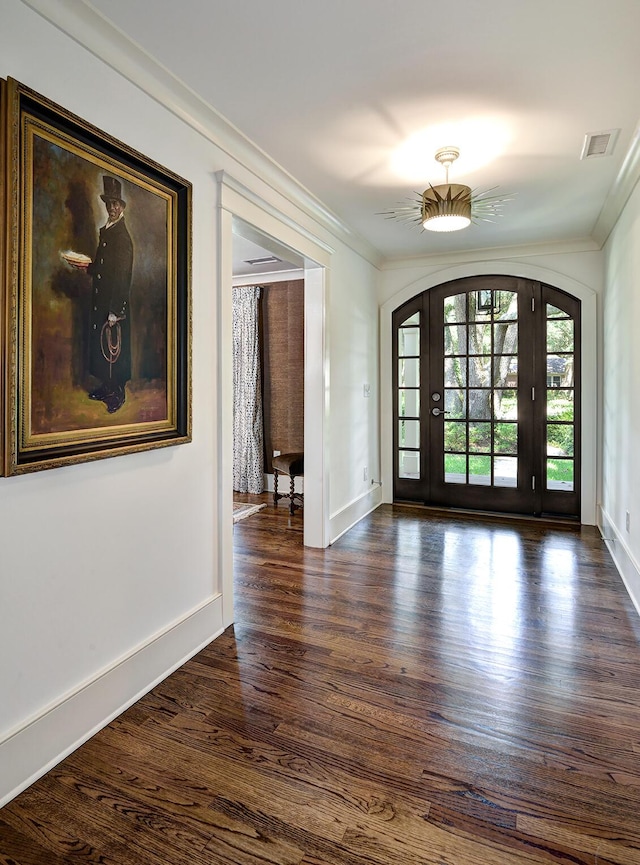 entryway with dark wood-type flooring, arched walkways, visible vents, and crown molding