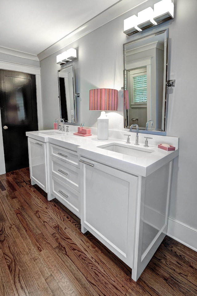 full bath with ornamental molding, wood finished floors, and a sink