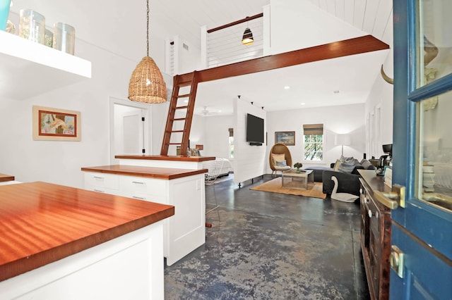interior space featuring a high ceiling, recessed lighting, and finished concrete floors