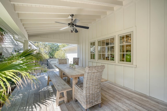 wooden terrace with outdoor dining area and a ceiling fan