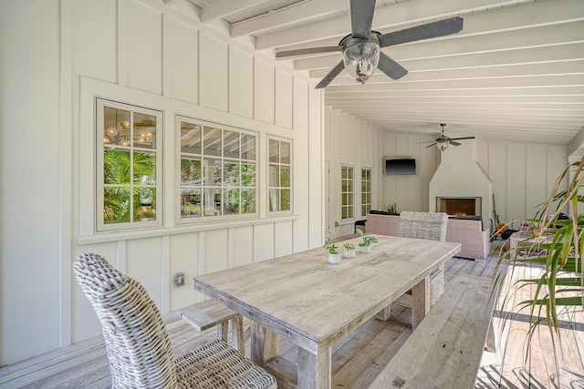 wooden terrace featuring outdoor dining space and ceiling fan