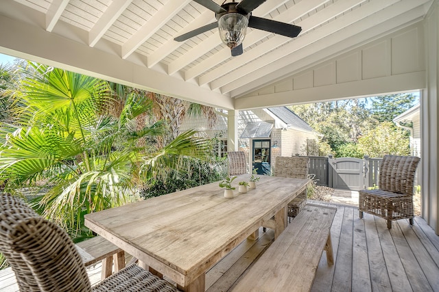 deck featuring outdoor dining area, a ceiling fan, and a gate