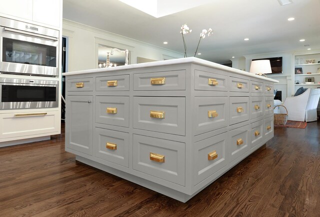 kitchen featuring stainless steel double oven, dark wood-type flooring, recessed lighting, and crown molding
