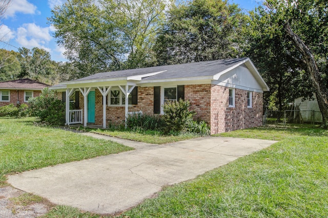 ranch-style house featuring covered porch and a front yard