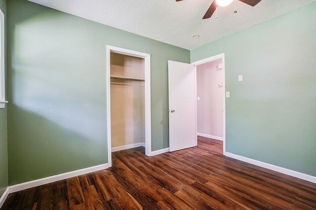 unfurnished bedroom with dark hardwood / wood-style flooring, a textured ceiling, and ceiling fan