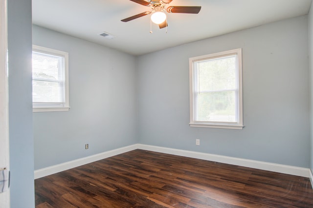 unfurnished room featuring a wealth of natural light, dark hardwood / wood-style floors, and ceiling fan