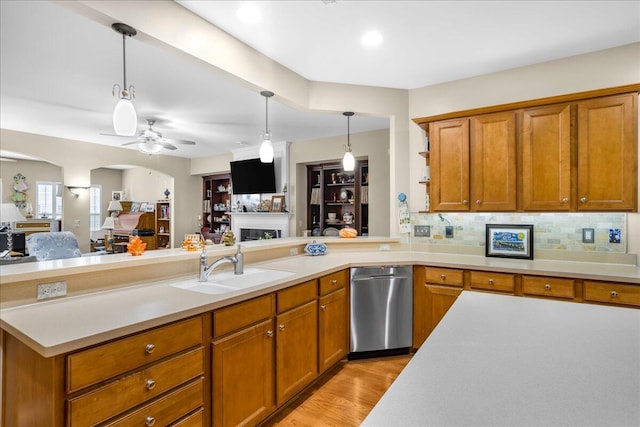 kitchen featuring ceiling fan, dishwasher, sink, tasteful backsplash, and light hardwood / wood-style flooring