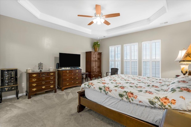 bedroom featuring ceiling fan, a raised ceiling, and light carpet