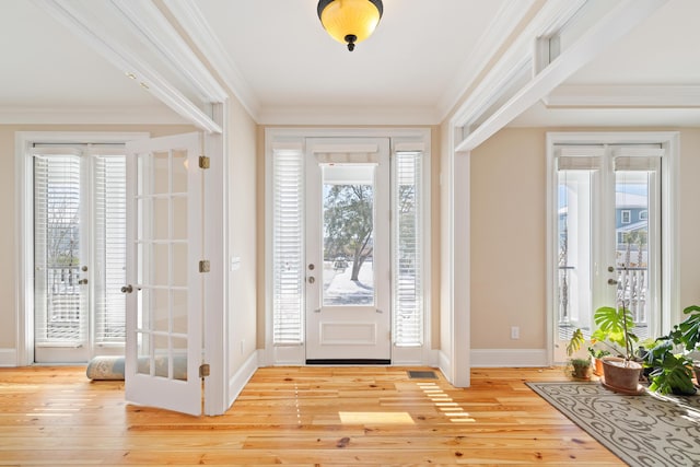 foyer featuring light hardwood / wood-style flooring, ornamental molding, and french doors