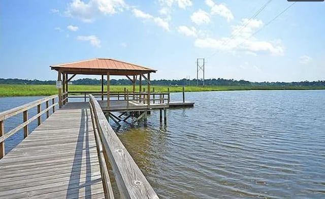 view of dock with a gazebo and a water view