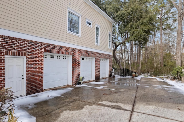 view of snowy exterior featuring a garage