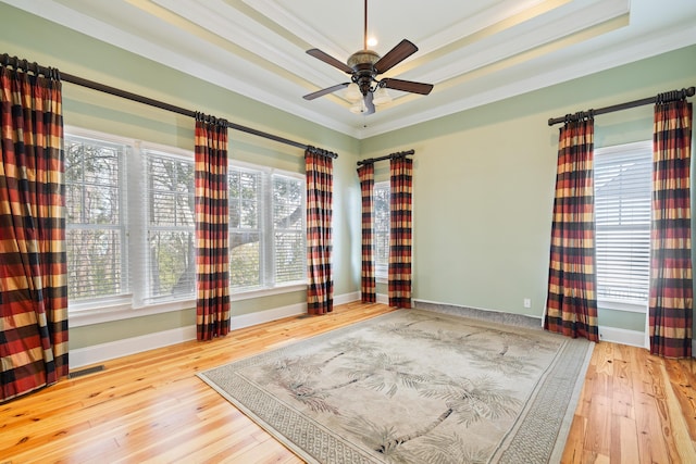 unfurnished room featuring ceiling fan, ornamental molding, a raised ceiling, and hardwood / wood-style floors