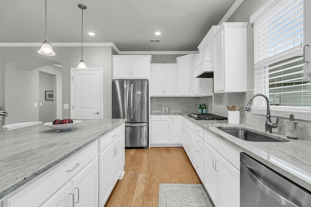 kitchen with white cabinetry, appliances with stainless steel finishes, sink, and light stone countertops