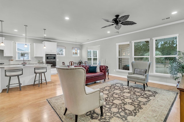 living room with ceiling fan, light hardwood / wood-style flooring, and ornamental molding