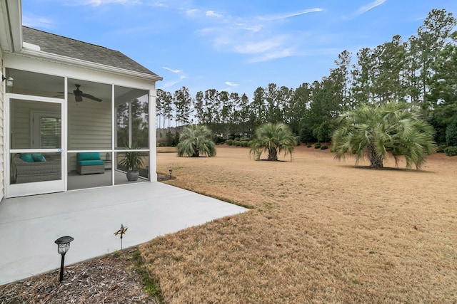 view of yard featuring ceiling fan, a patio area, and a sunroom