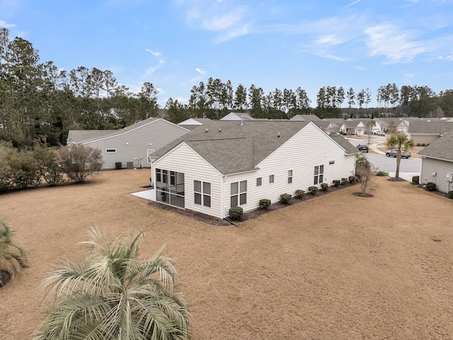 rear view of property with a yard and a sunroom