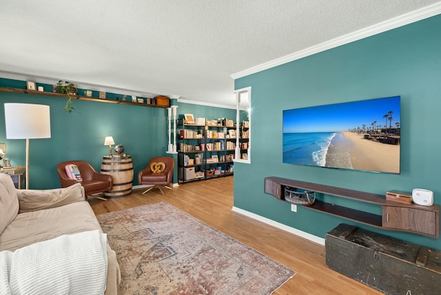 living room with baseboards, a textured ceiling, wood finished floors, and crown molding