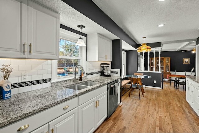 kitchen with dishwasher, light wood-style floors, white cabinetry, and a sink