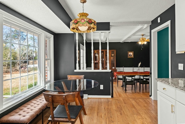 dining space with beamed ceiling, light wood-type flooring, and ceiling fan