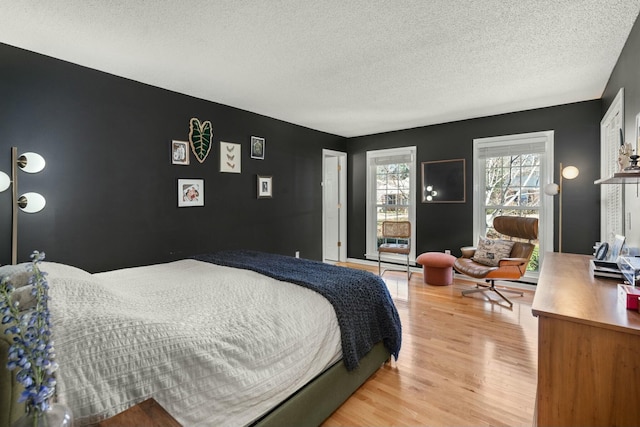 bedroom featuring light wood finished floors and a textured ceiling