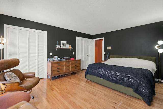 bedroom featuring wood finished floors and two closets