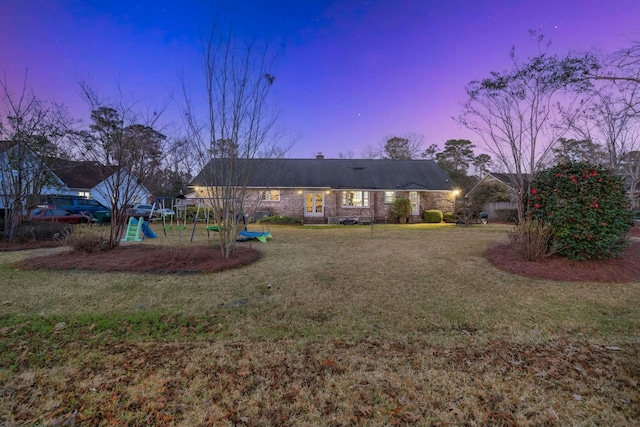 view of front of property with a playground, a yard, and a chimney