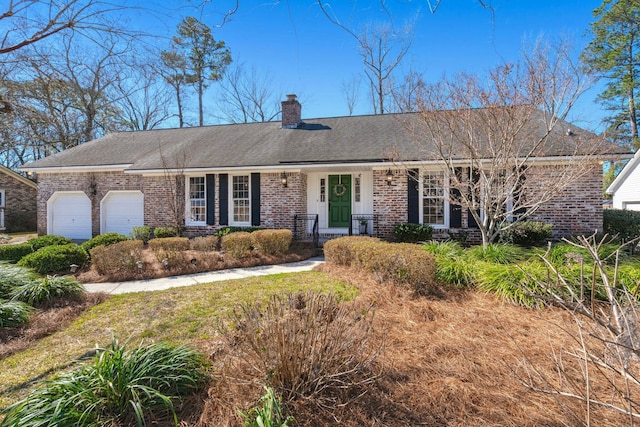 ranch-style home with brick siding, an attached garage, a chimney, and roof with shingles