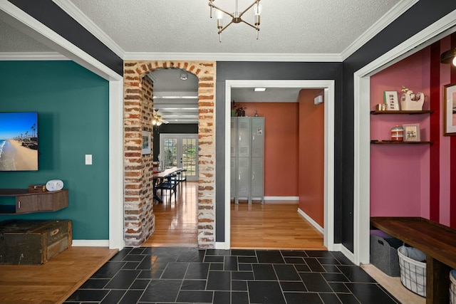 interior space with an inviting chandelier, ornamental molding, dark wood-type flooring, and a textured ceiling