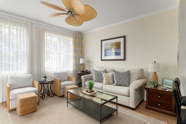 living room with ceiling fan, plenty of natural light, light wood-type flooring, and crown molding