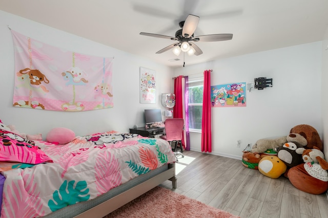 bedroom with ceiling fan, visible vents, baseboards, and wood finished floors