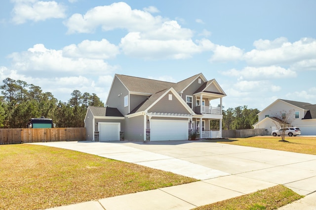 view of front of home with a front lawn, driveway, fence, a garage, and a balcony