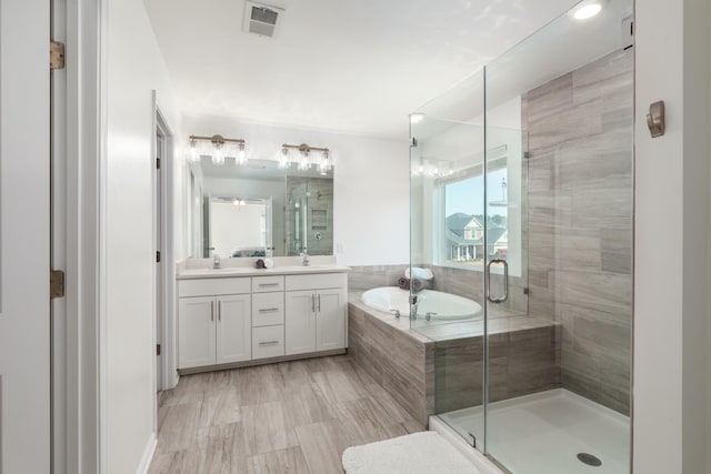 bathroom with double vanity, a bath, a stall shower, and a sink