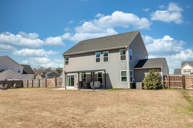 rear view of house featuring a fenced backyard, a lawn, cooling unit, and a patio