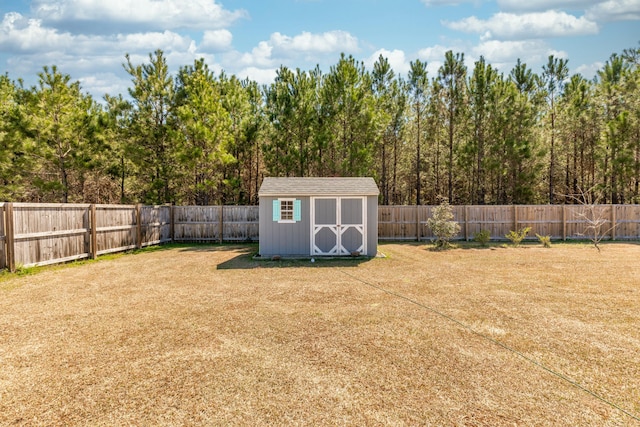 view of yard featuring a storage unit, a fenced backyard, and an outdoor structure