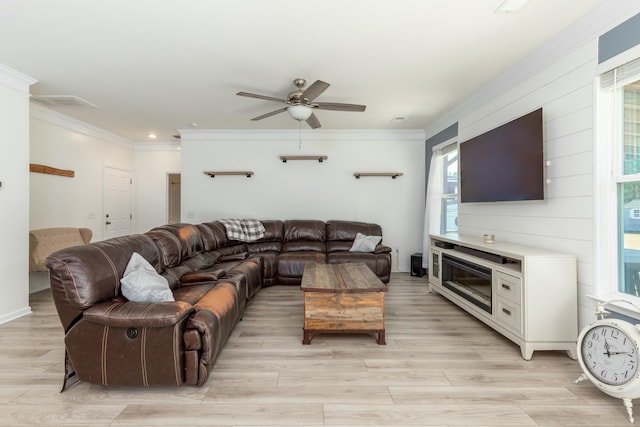 living room featuring light wood-style flooring, ornamental molding, and a ceiling fan