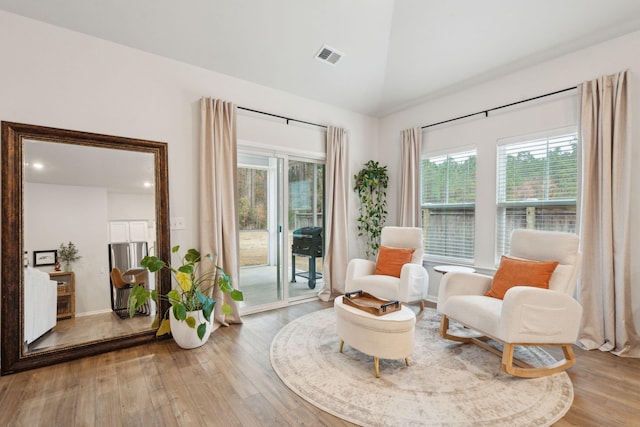 sitting room with light hardwood / wood-style floors, a wealth of natural light, and lofted ceiling