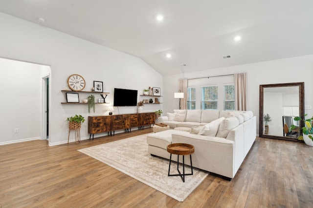 living room with lofted ceiling and light hardwood / wood-style flooring