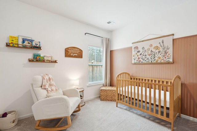 carpeted bedroom featuring a crib